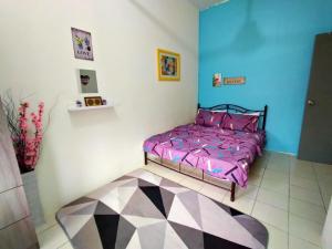 a bedroom with a bed with a purple comforter at Umai homestay in Bandar  Pusat Jengka