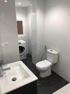 een witte badkamer met een toilet en een wastafel bij Amazing View Apartment Estepona Puerto in Estepona