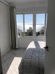 um quarto com uma grande janela com vista para o oceano em Amazing View Apartment Estepona Puerto em Estepona