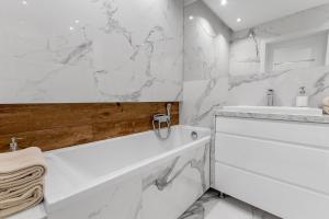 a white bathroom with a tub and a sink at HARBOR APARTMENTS - Pułaskiego in Katowice +27 photos