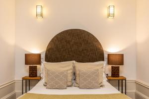 a bedroom with a bed with two lamps at YOUROPO - Stories in Porto