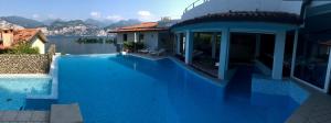 a large blue swimming pool next to a house at Hotel Garden in Malcesine