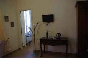 a room with a table and a television on a wall at Tucci's Roma Guest House in Rome