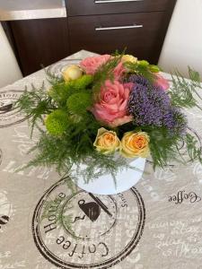 um ramo de flores num vaso sobre uma mesa em Elegantz Apartments 2 em Varna City