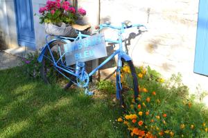 ein blaues Fahrrad parkt im Gras mit einem Schild drauf in der Unterkunft L'instant bleu in Marans
