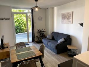 uma sala de estar com um sofá azul e uma mesa em L'industriel, T2, wifi et parking em Thonon-les-Bains