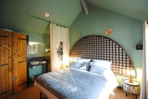 1 dormitorio con 1 cama grande y cabecero de madera en Les meublés du Grand Logis, en Marchais