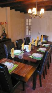 een eettafel met stoelen en een grote houten tafel bij L'OURSERIE Bed & Breakfast in Saint-Paul-en-Chablais