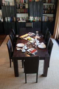 - une table en bois avec des chaises, des assiettes et de la nourriture dans l'établissement Luxus-Landhaus im Schwarzwald/Baiersbronn mit Pool, à Baiersbronn