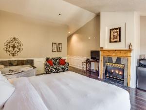 a bedroom with a large bed and a fireplace at Leavenworth Village Inn in Leavenworth