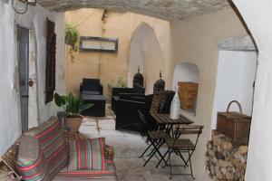 a living room with a couch and a table and chairs at Maison Anila in Barjac