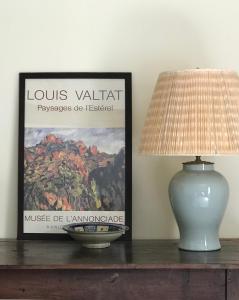 a lamp and a picture on a table with a vase at La maison Jeanne d'Arc in Saint-Fargeau +79 photos