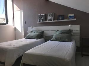 two beds sitting next to each other in a room at Maison Loiseau - Maison Calme au Centre de Beaune in Beaune
