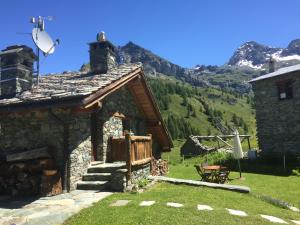 una casa in pietra con una montagna sullo sfondo di CHALET GORRET CHENEIL a Valtournenche