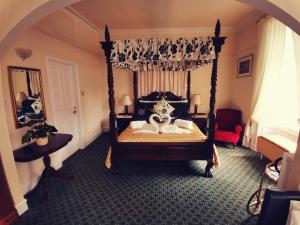 a bedroom with a canopy bed with two swans on it at Victoria Hotel in Blairgowrie