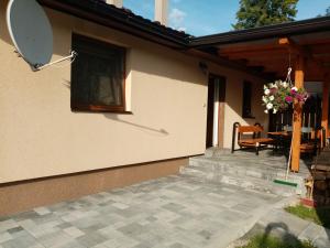 a house with a patio and a table with flowers at Domek in Reľov