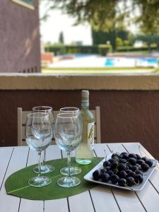 een tafel met drie wijnglazen en een bord druiven bij Welcome Traveller APPARTAMENTO CASETTO in Bardolino