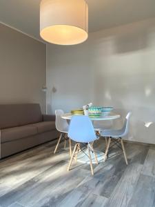 een woonkamer met een tafel en stoelen en een bank bij Welcome Traveller APPARTAMENTO CASETTO in Bardolino