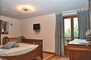 a bedroom with a bed and a tv and a window at Lo Pallier de Ré in Aymavilles