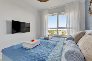 1 dormitorio con 1 cama azul y 2 almohadas en Baltica SeaView by TriApart, en Gdansk