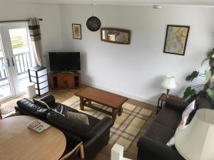 uma sala de estar com um sofá e uma mesa em Carrick Hills Cosy Croft em Dunure