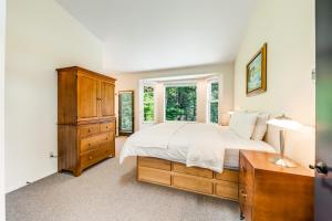 um quarto com uma cama, uma cómoda e uma janela em Cove Beach Forest Splendor em Arch Cape