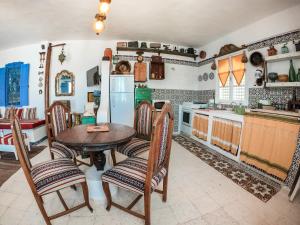 eine Küche mit einem Tisch und Stühlen sowie einem Kühlschrank in der Unterkunft El houch الحوش in Port El-Kantaoui