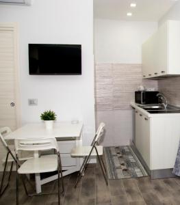 eine Küche mit einem kleinen Tisch und Stühlen sowie eine Küche mit einer Mikrowelle in der Unterkunft Casa Marmolo - Cuore di Napoli in Neapel