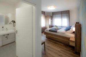 - une chambre avec un lit, un lavabo et un miroir dans l'établissement Mato One Zimmervermietung, à Arnsberg