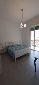Habitación blanca con cama y ventana en Renda Apartments, en Trapani