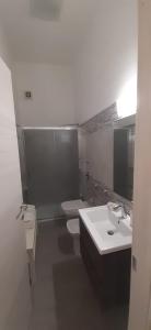 a white bathroom with two sinks and two toilets at Renda Apartments in Trapani