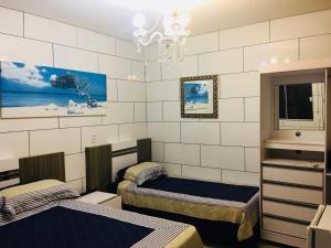 Cette chambre comprend 2 lits et une télévision. dans l'établissement Hotel das Palmas, à Florianópolis