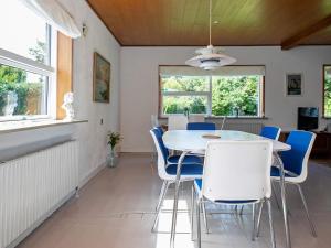 a dining room with a table and blue chairs at Holiday home Varde II in Varde