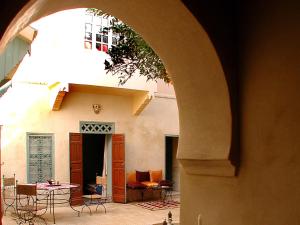 un arco en un edificio con mesa y sillas en Riad Dar Marhaba en Marrakech