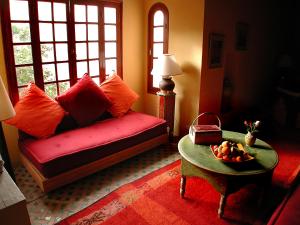sala de estar con sofá rojo y mesa en Riad Dar Marhaba, en Marrakech