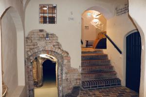 eine Treppe in einem Gebäude mit einem steinernen Torbogen in der Unterkunft Markt 15 Gästehaus in Senftenberg