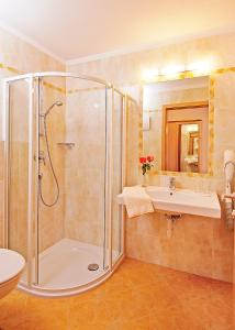 a bathroom with a shower and a sink at Garni-Hotel mir.es in Tirolo