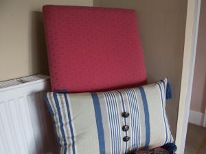 una sedia rosa seduta accanto a un cuscino di The Old Manor House B & B a Brasted