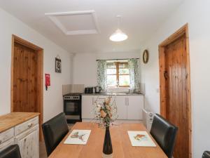 a kitchen with a wooden table with chairs and a dining room at The Old Goat Barn at Trout Cottage in Somerton