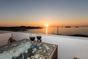 due bicchieri di vino seduti su un tavolo con il tramonto di Vesleme a Pachaina