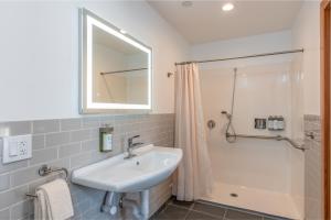 La salle de bains est pourvue d'un lavabo et d'une douche. dans l'établissement Wildflower Boutique Motel, à Point Arena