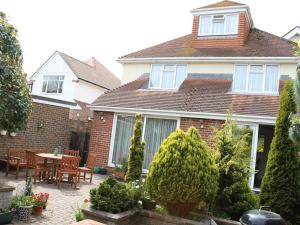 Casa con patio con mesa y sillas en Merton House, en Worthing