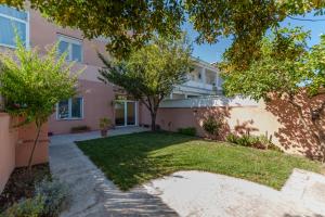 a pink house with trees in front of it at Uliveto' s Apartment in Elmas