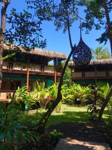 a resort with a building with a tree at Boa Village- Bungalow com Piscina Natural- Praia de Algodões in Marau