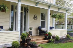 Maplehurst Manor Bed and Breakfast في Dorchester: شرفة منزل بها نباتات الفخار