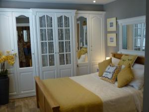 a bedroom with a large bed with white cabinets at Morans Bed and Breakfast @ Lower Lodge in Westward Ho