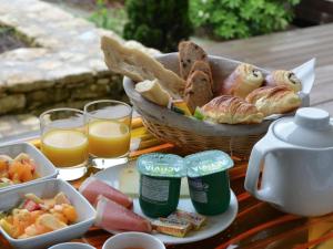 una mesa con una cesta de pan y vasos de zumo de naranja en Nature & Design en Bonifacio