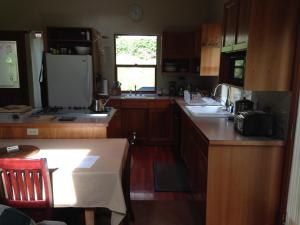 - une cuisine avec des placards en bois et un réfrigérateur blanc dans l'établissement Nettles Farm, à Lummi Island