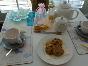 a table with a plate of cookies and cups on it at Morans Bed and Breakfast @ Lower Lodge in Westward Ho