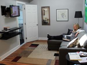 una mujer sentada en un sofá en una sala de estar en Merrickville Guest Suites en Merrickville